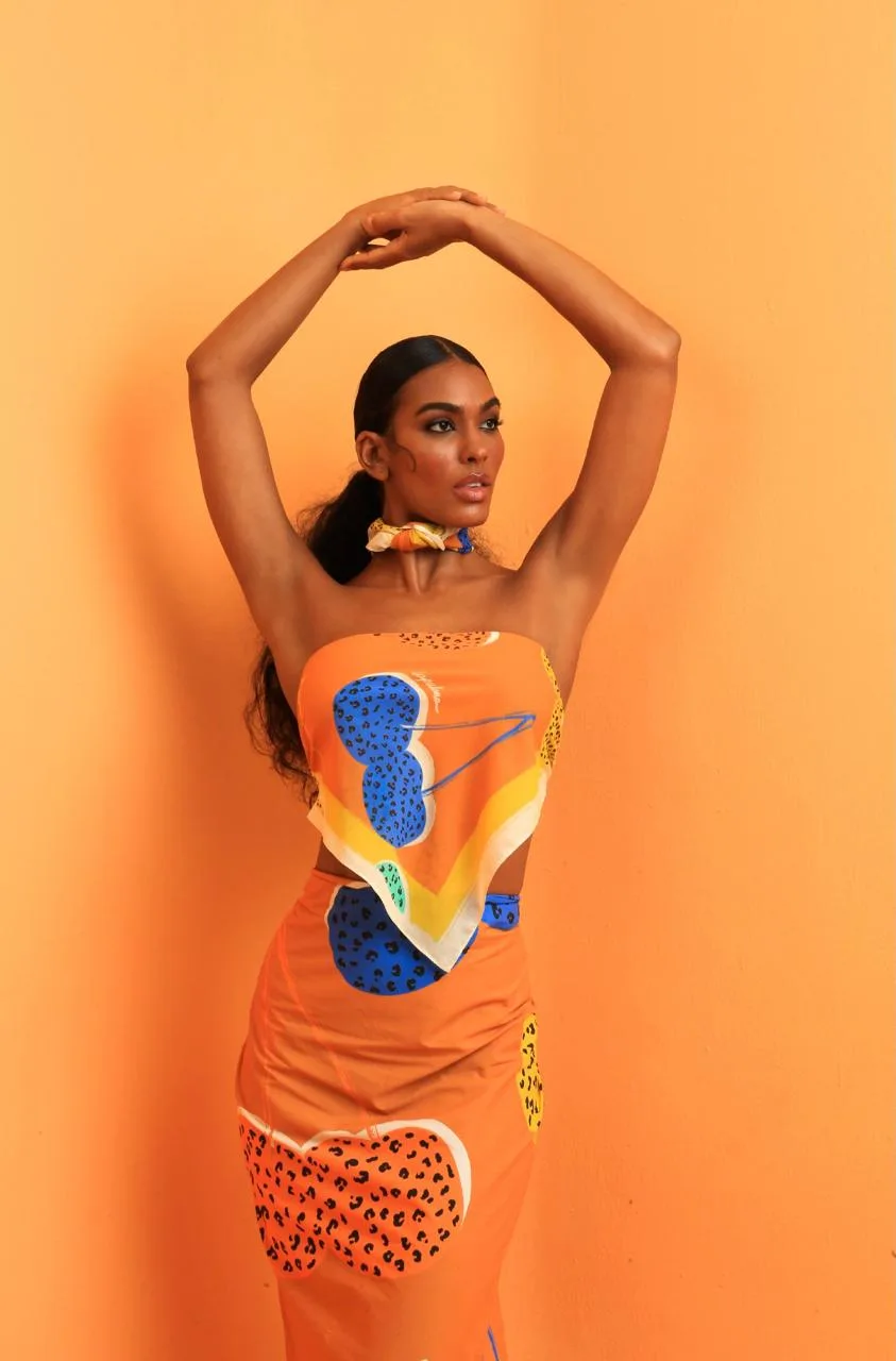 Anaiza Ferreira in a graphic print look against an orange backdrop